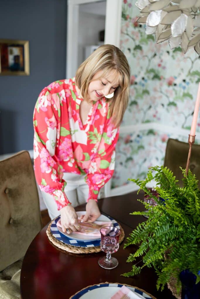 Woman laying forks on a place setting.