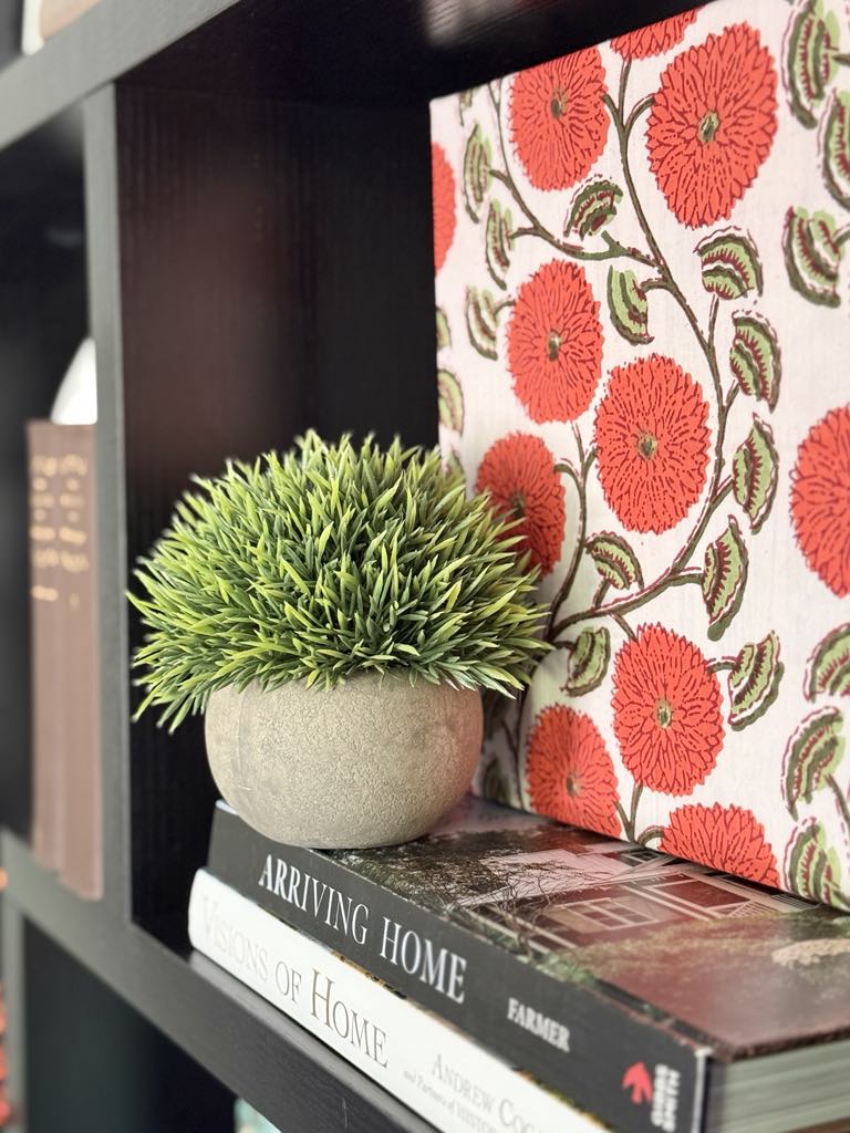 Block print canvas decorating a bookshelf.