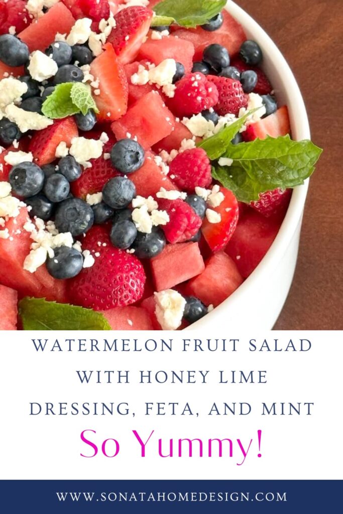 A white bowl filled with watermelon fruit salad with honey lime dressing, feta cheese, and fresh mint.