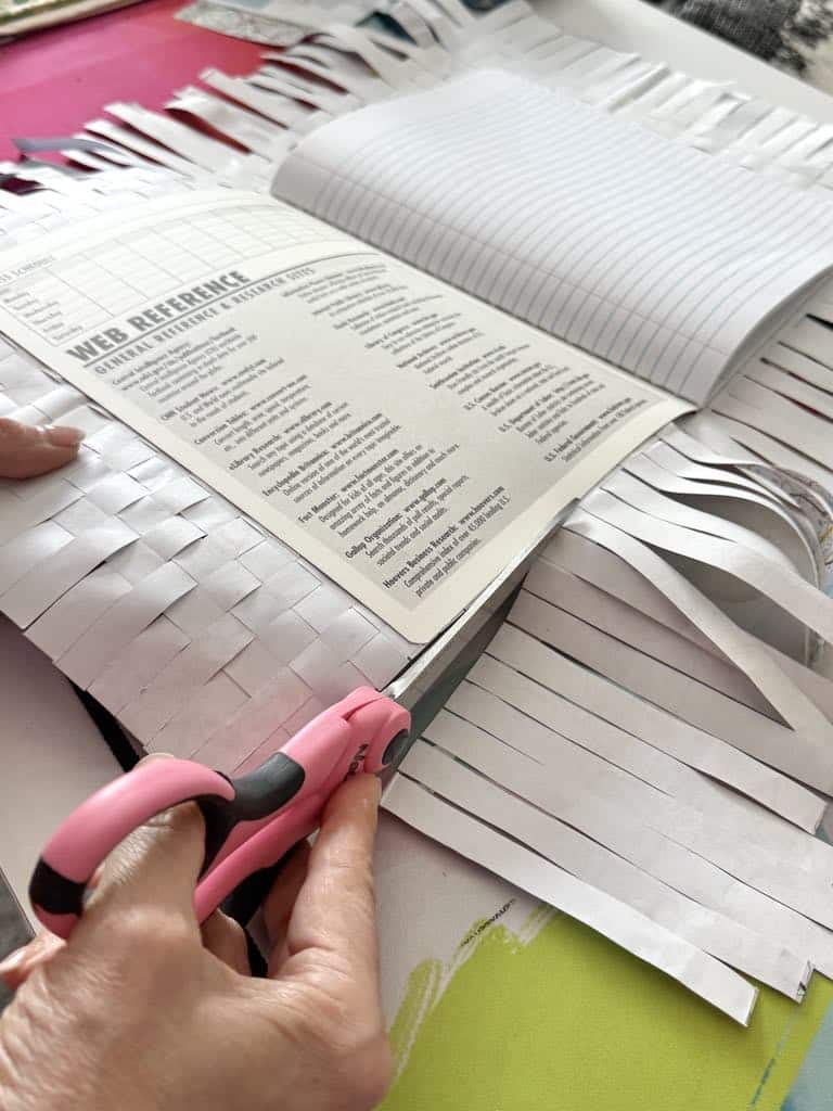 Cutting excess strips from travel journal diy project.