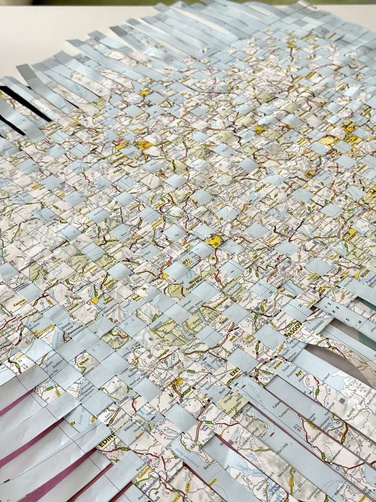A woven mat made from map strips for a diy travel journal.