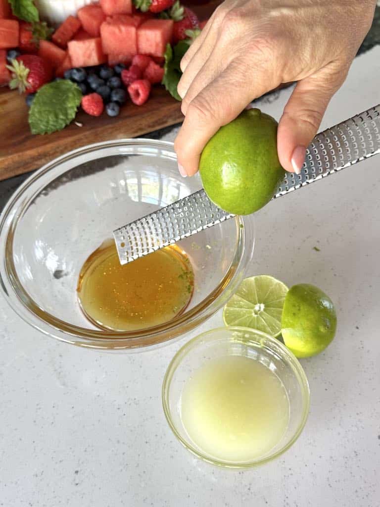 Zesting a lime for honey lime dressing for a watermelon fruit salad.
