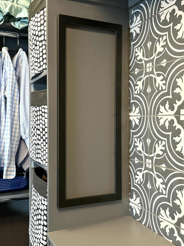 A painted empty frame hanging on a partial closet wall for sunglasses organization.