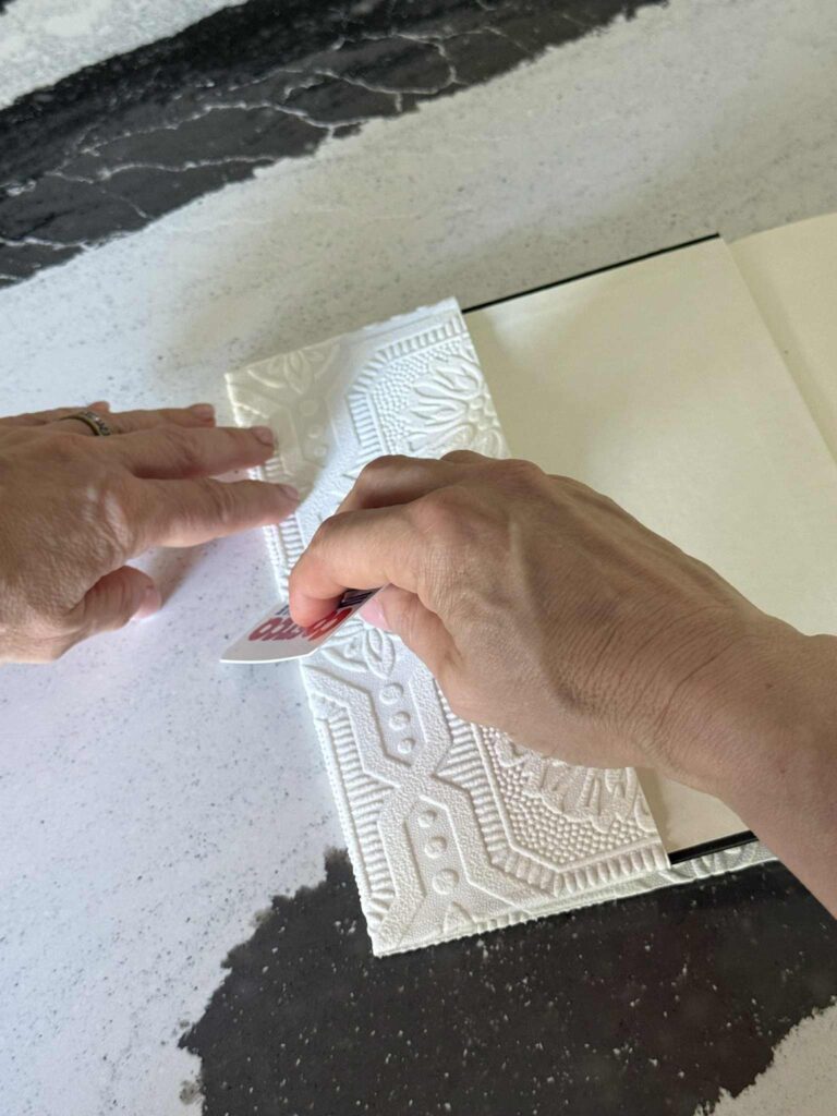 Pressing the crease of. diy book cover with a credit card.