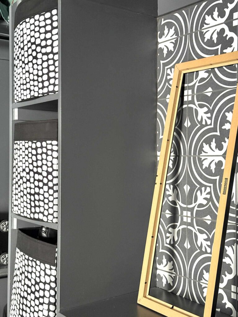 An empty wall frame next to a partial wall in a closet to be used for sunglasses and reading glasses storage and organization.