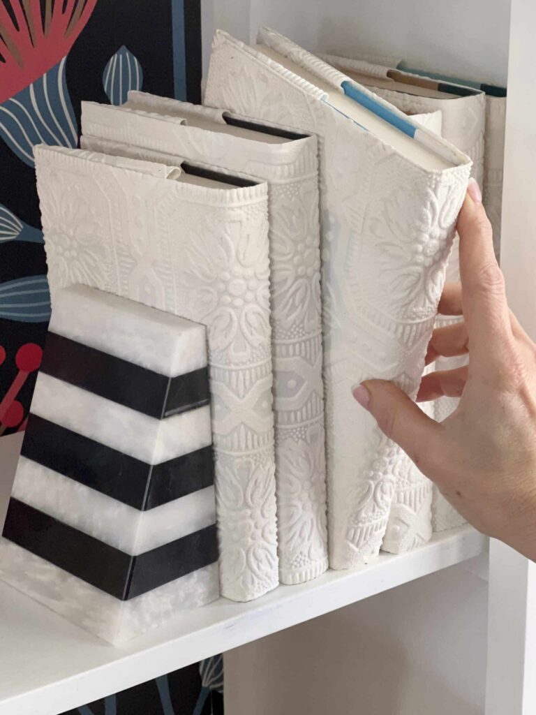 Pulling a book with a DIY book cover from a shelf.