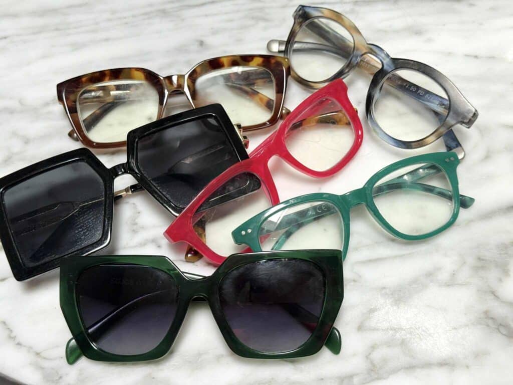 A variety of sunglasses and reading glasses in need or organization.