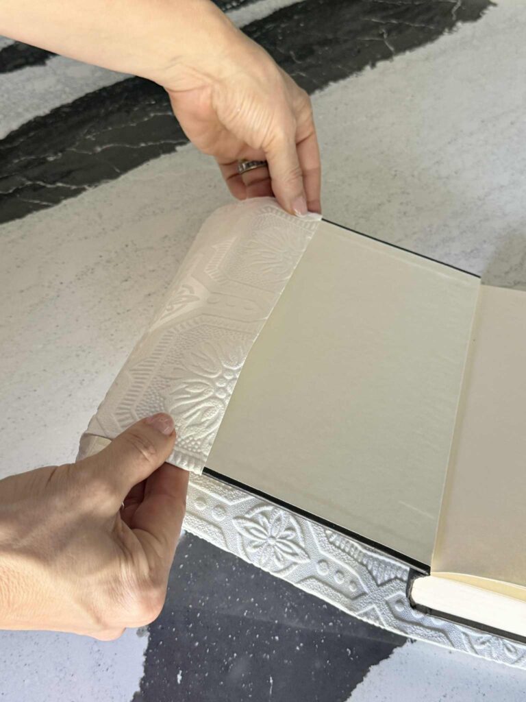 Folding a book cover onto one end of a book.