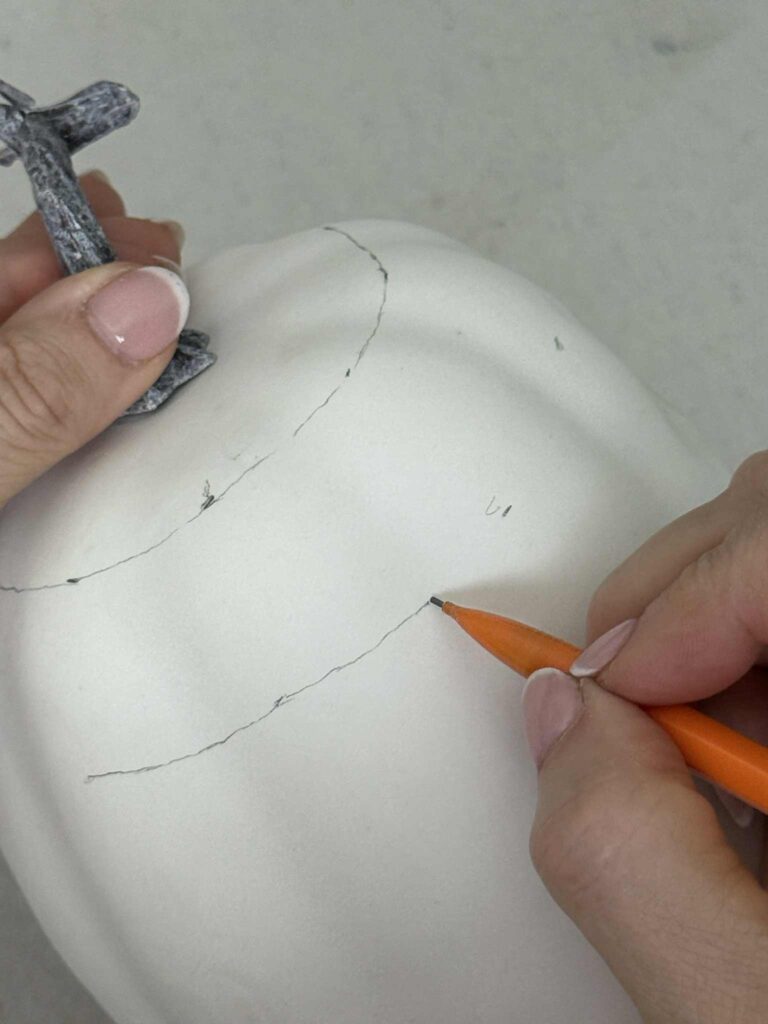 Connecting marked dots with a pencil for checkered pumpkin DIY.