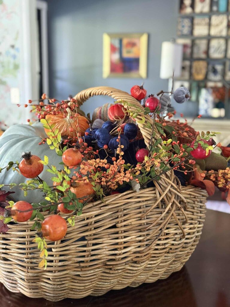 A simple fall decor idea is filling a basket with faux fall florals.