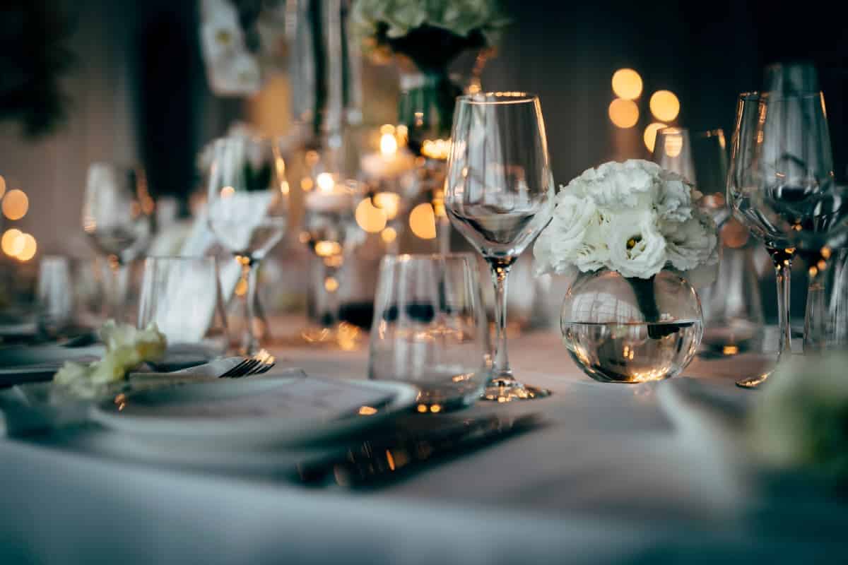 A formal dining table set with china and goblets.