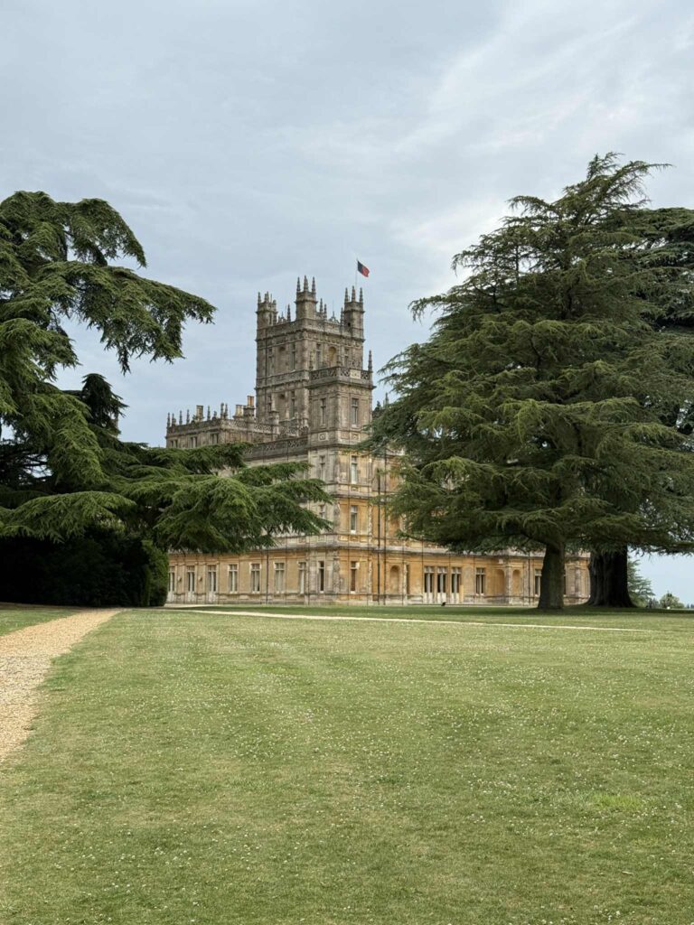 A view of Highclere Castle flanked by trees as part of the Downton Abbey Tour.