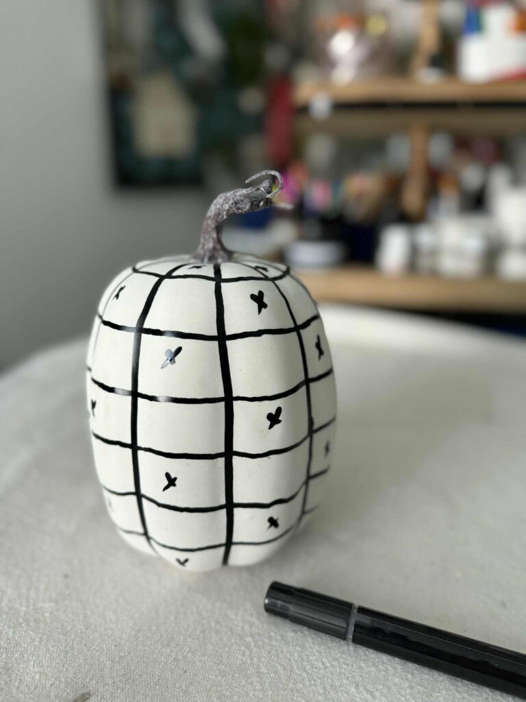 Marked X's to designate squares to be painted on a checkered pumpkin.