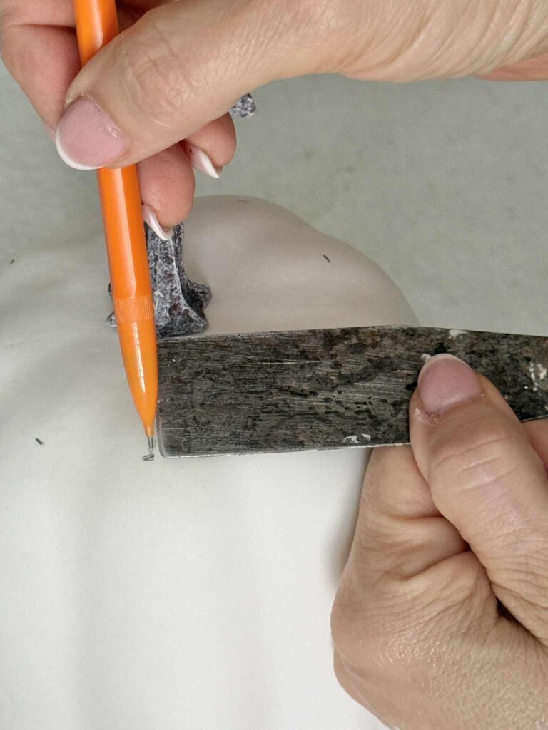 Measuring for spacing dots on a faux pumpkin.