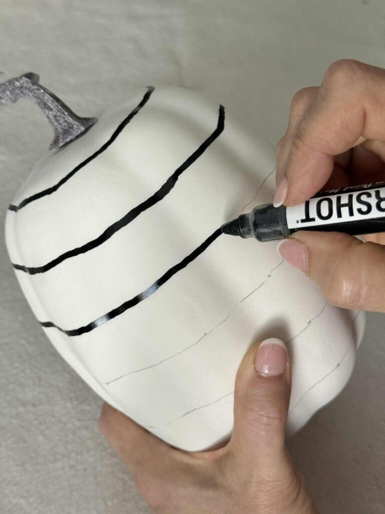 Outlining horizontal pencil lines for a DIY checkerboard fall pumpkin.