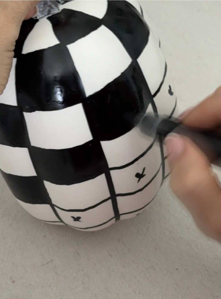 Painting squares on a faux pumpkin.