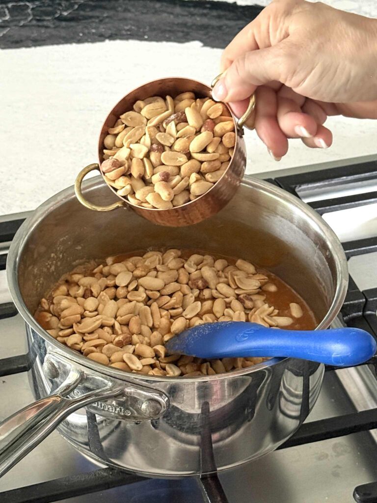 Adding peanuts to a caramel mixture for Salted Peanut Bars.