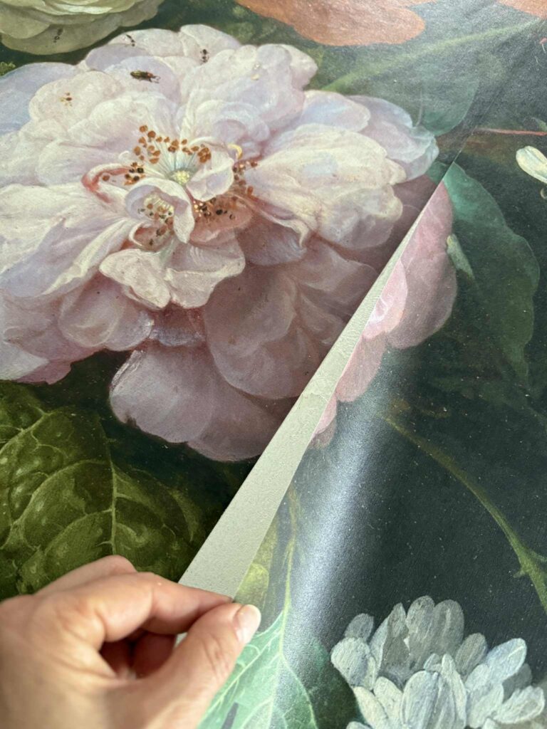 Matching seams of floral wallpaper on a canvas.