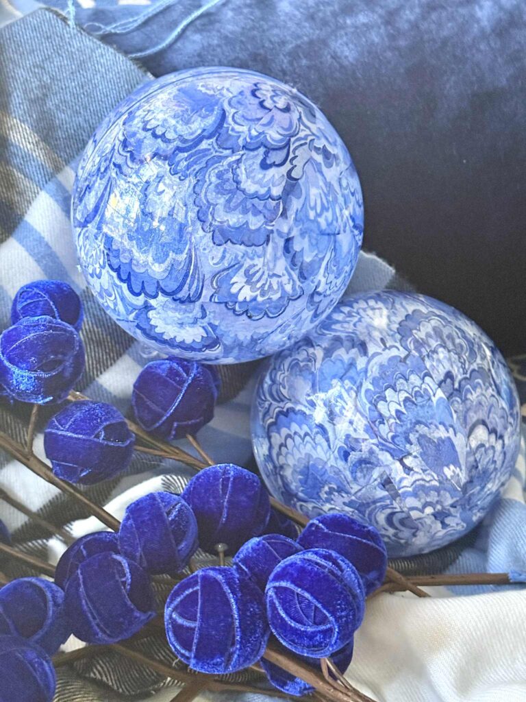 Two blue and white decoupage ornaments with blue velvet Christmas tree picks.