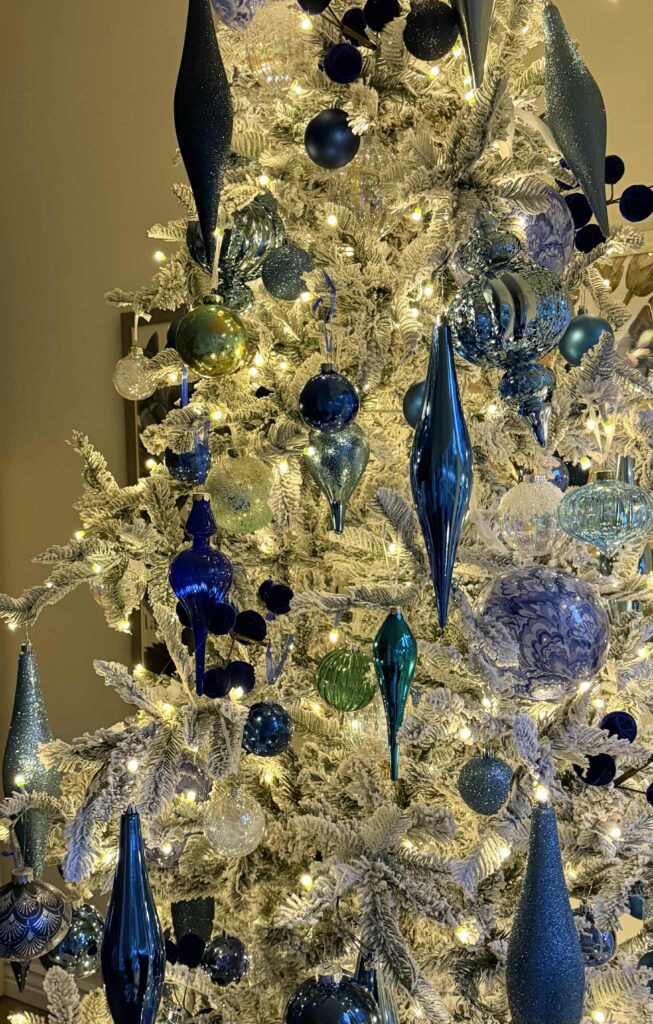 An illuminated decorated flocked Christmas tree.