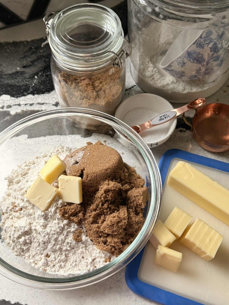 A bowl full of flour, brown sugar, and butter.