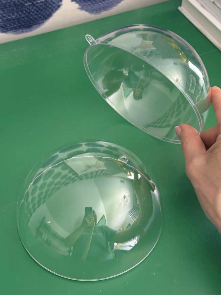 Two halves of a clear Christmas ornament.