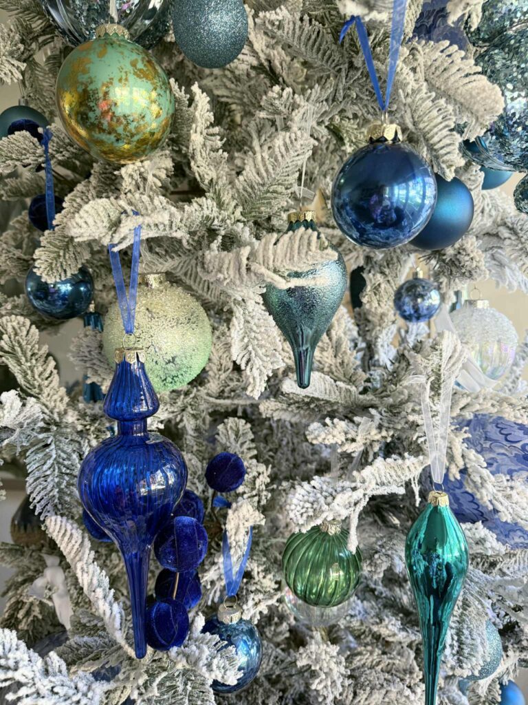 Christmas tree ornaments decorating a flocked tree.