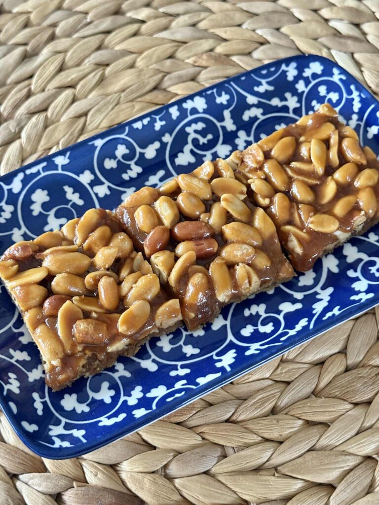 A blue tray holding three salted peanut bars.