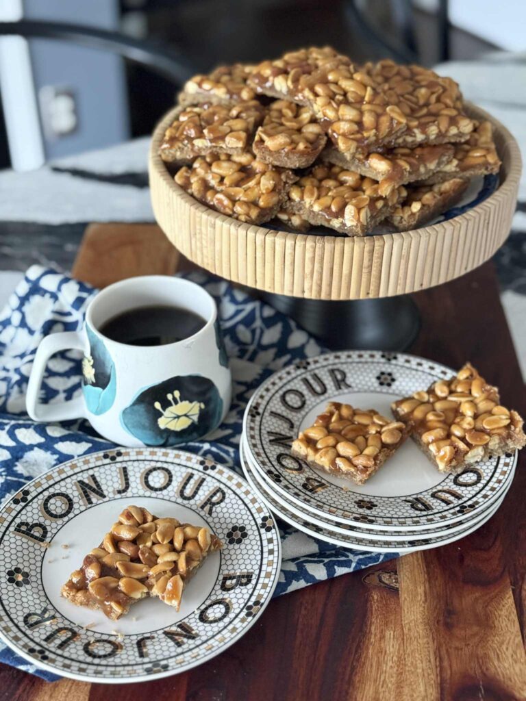 Salted Peanut Bars on a pedestal sitting next two plates filled with more bars.