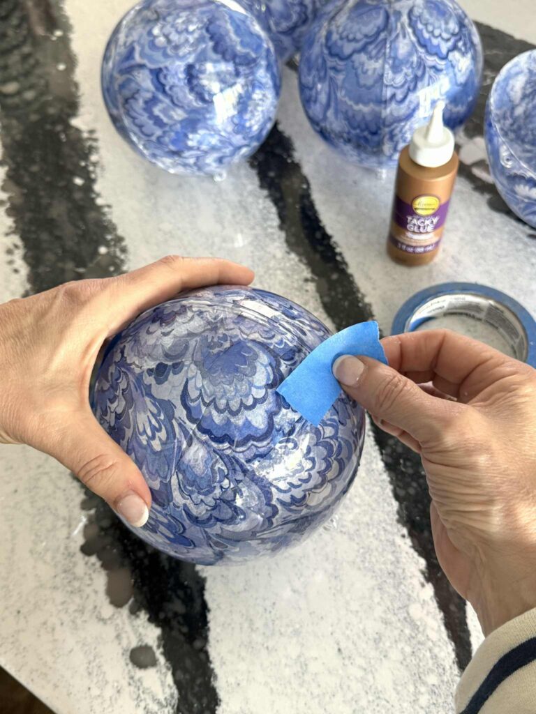 Applying painter's tape to ornament halves.