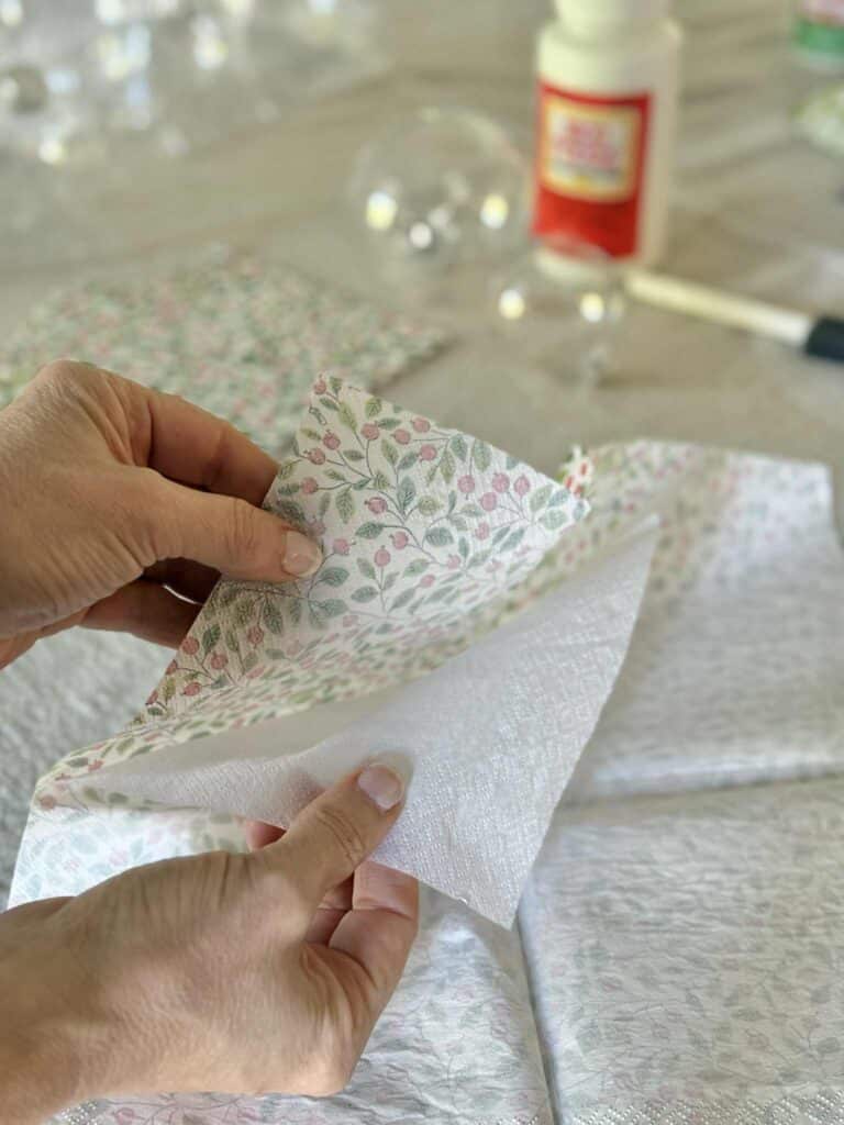 Peeling apart the layers of a paper napkin for a decoupage project.