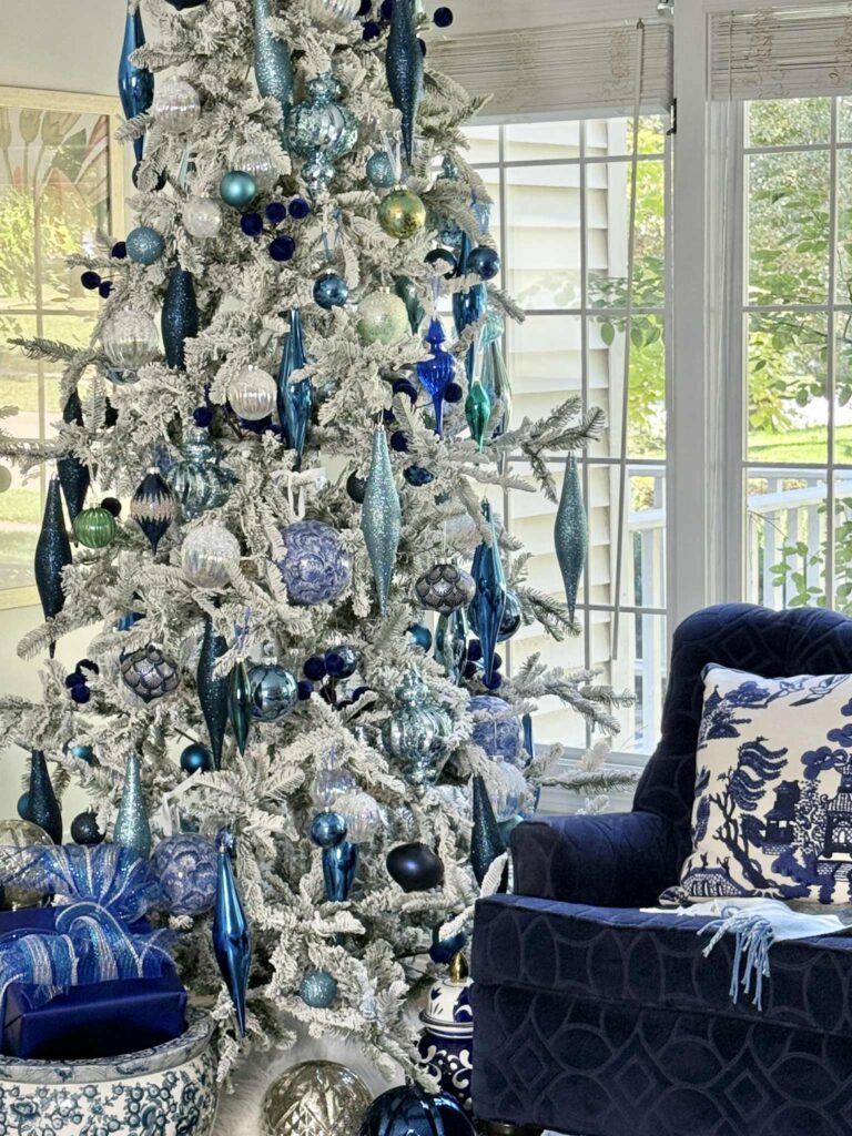 Decorating Ideas for a flocked Christmas tree: Dangling ornaments in shades of blue on a flocked tree.