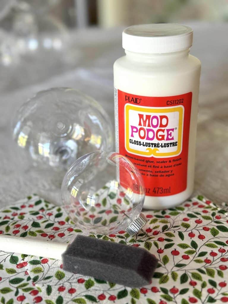 A clear ornament ball and a bottle of ModPodge decupage glue.
