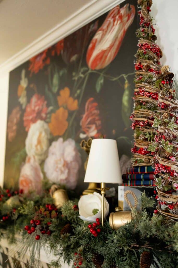 A lamp sitting on a fireplace mantel decorated for Christmas.
