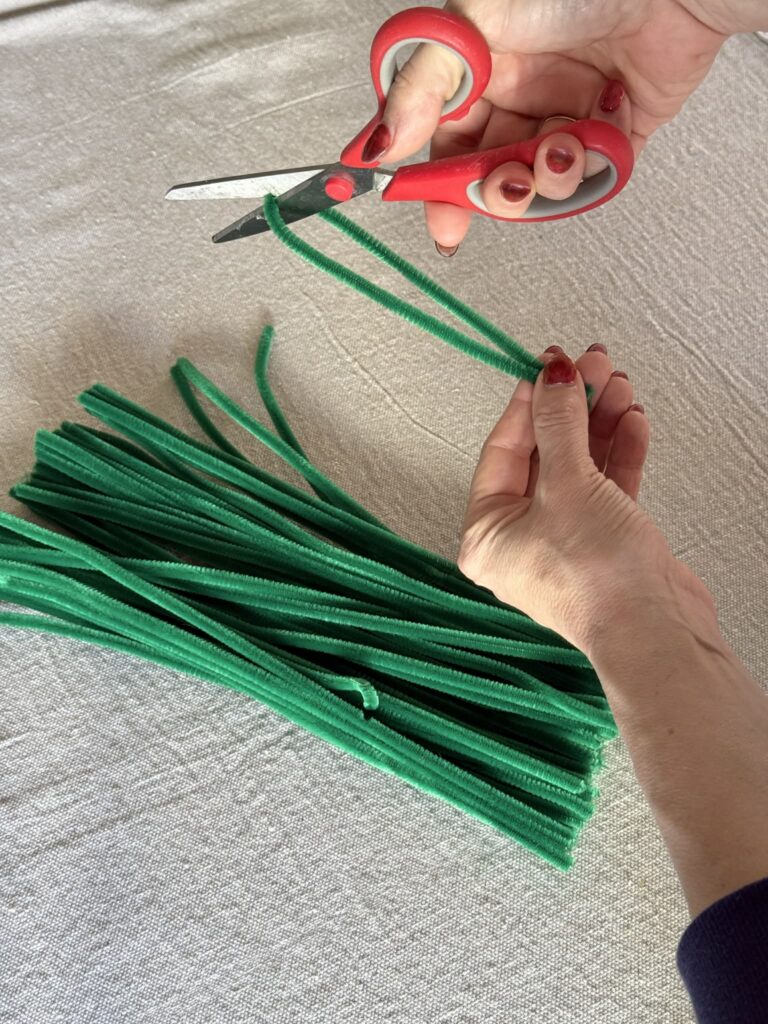Cutting green pipe cleaners in half.