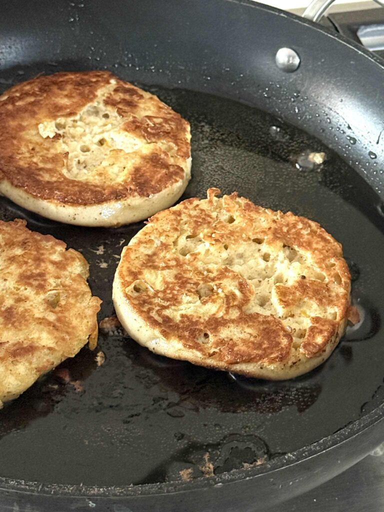 Frying English muffins in a skillet as French toast.