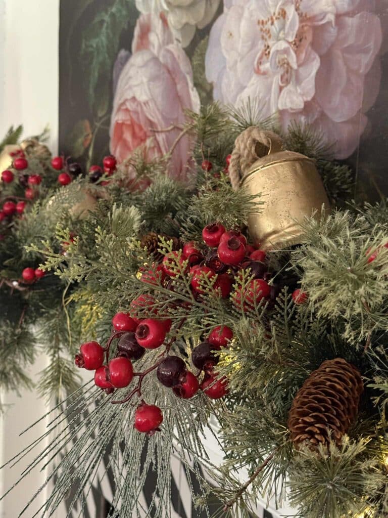 Fireplace mantel decorated with greenery, berries, and brass bells for Ralph Lauren inspired Christmas.