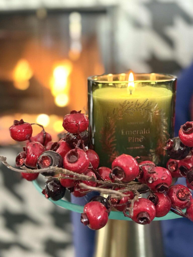 A Christmas candle sitting in a berry ring.