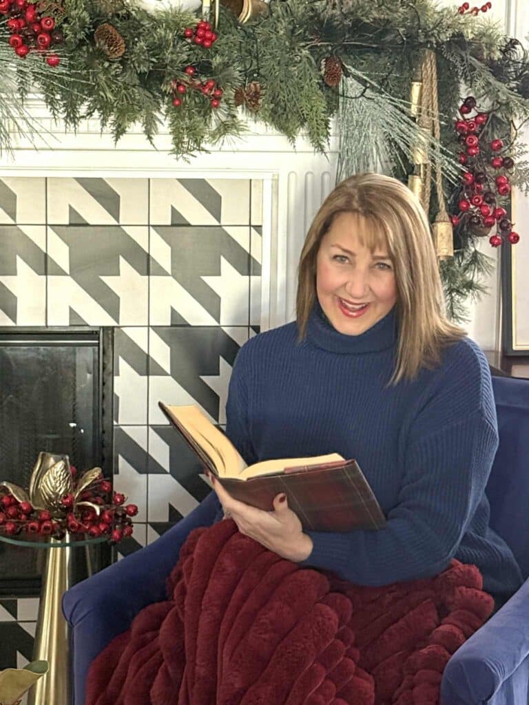 Woman sitting in front of a Ralph Lauren inspired Christmas fireplace mantel.