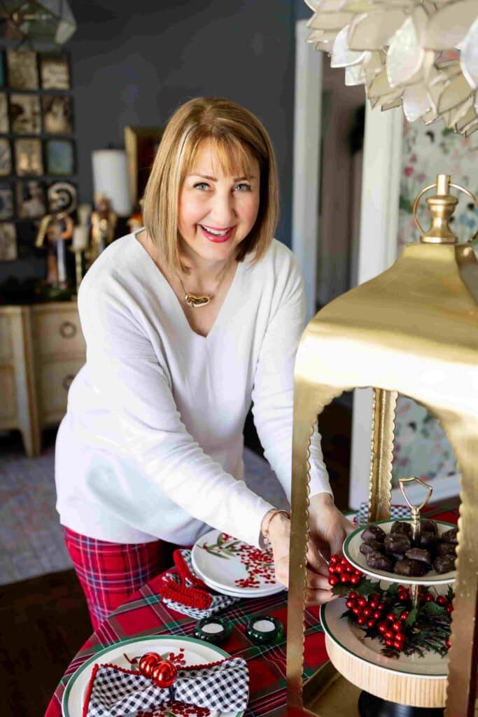 Woman decorating a dining room table for Christmas.