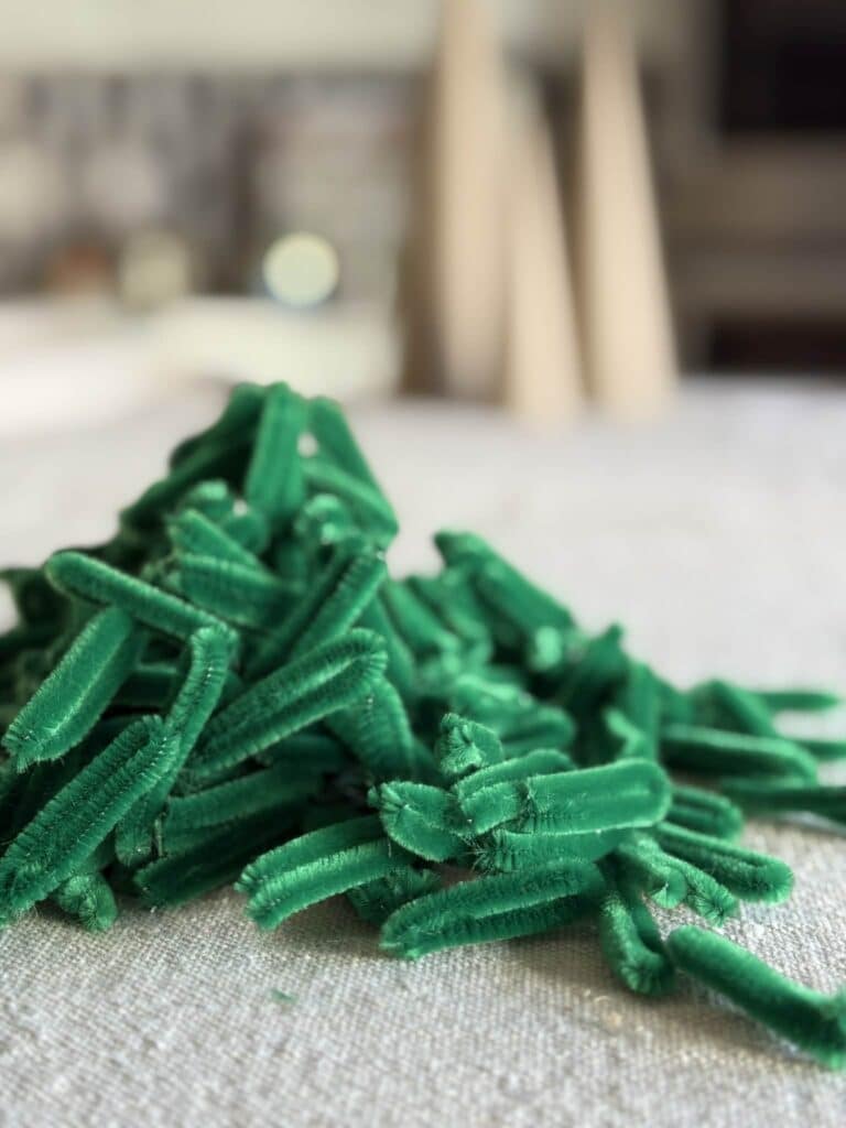 Pile of green pipe cleaner loops for pipe cleaner Christmas tree.