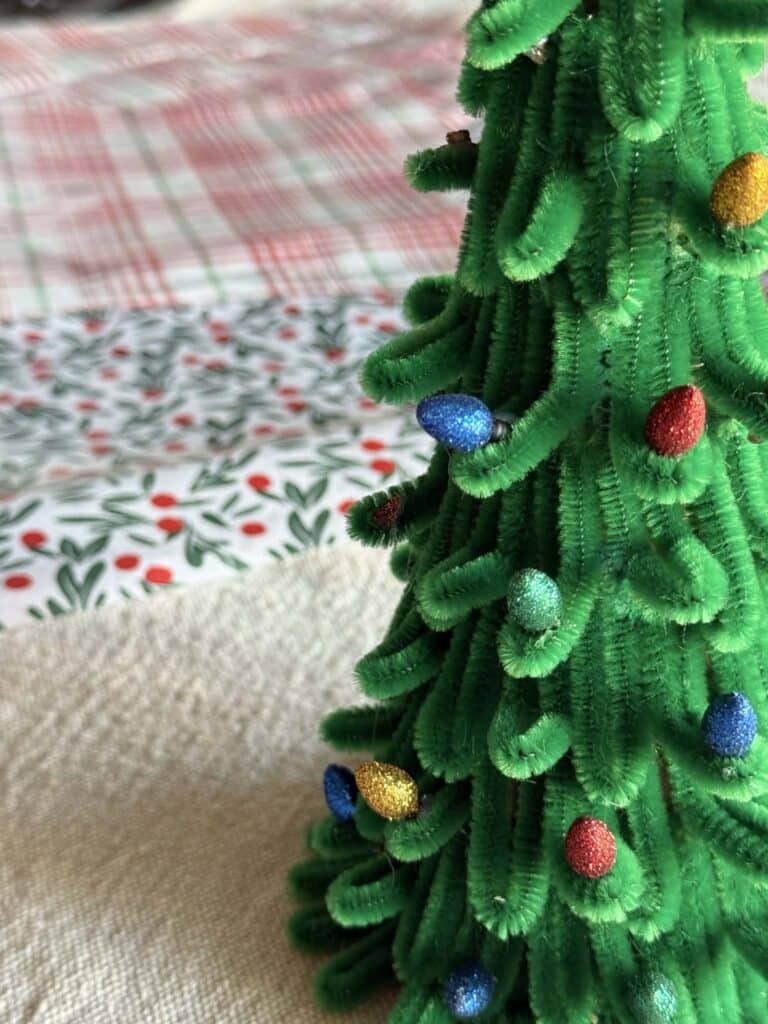 Tiny Christmas lightbulbs on a pipe cleaner Christmas tree.