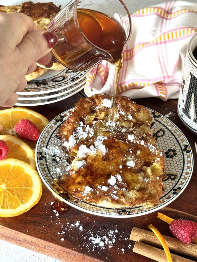 Pouring maple syrup over English muffins French toast.