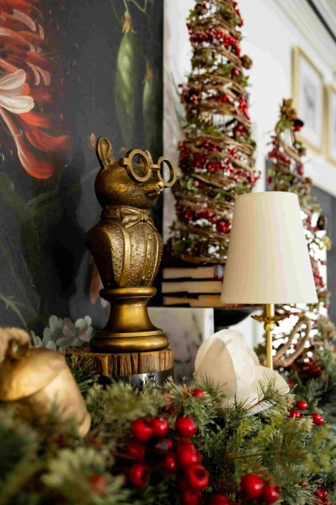 Brass accents nestled into Christmas greenery on a fireplace mantel.