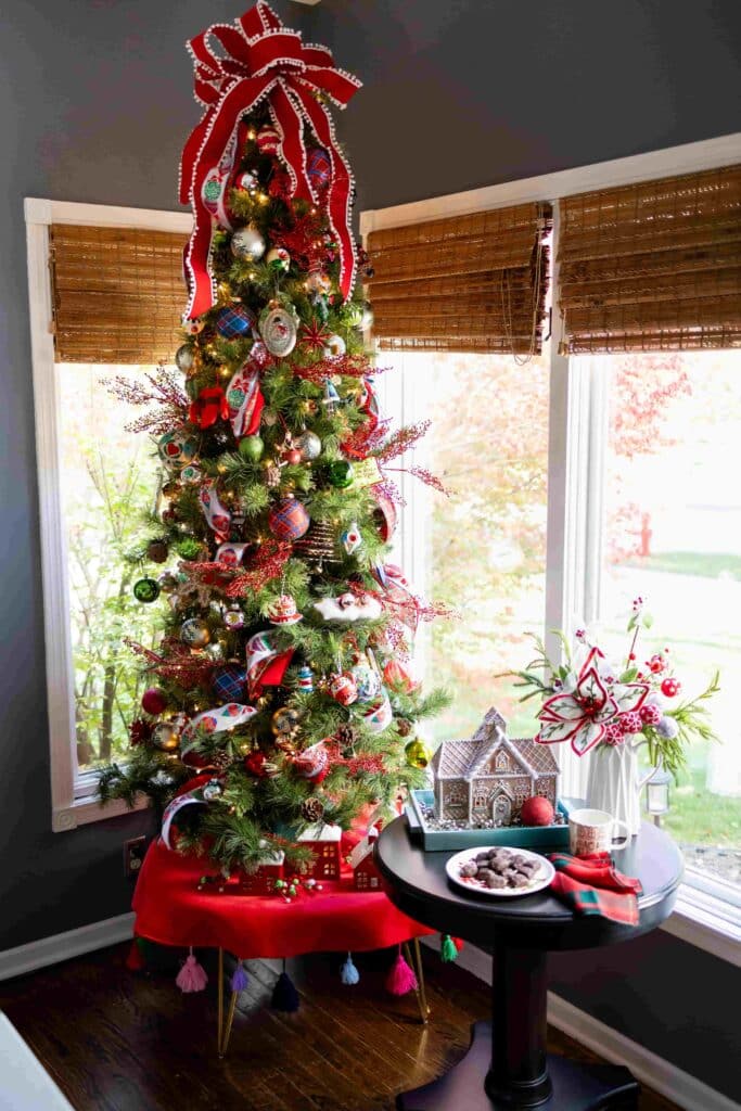 A Christmas tree elevated on a small table in a kitchen.