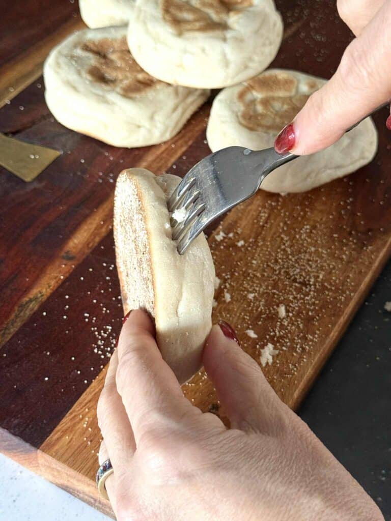 Separating English muffins with a fork.