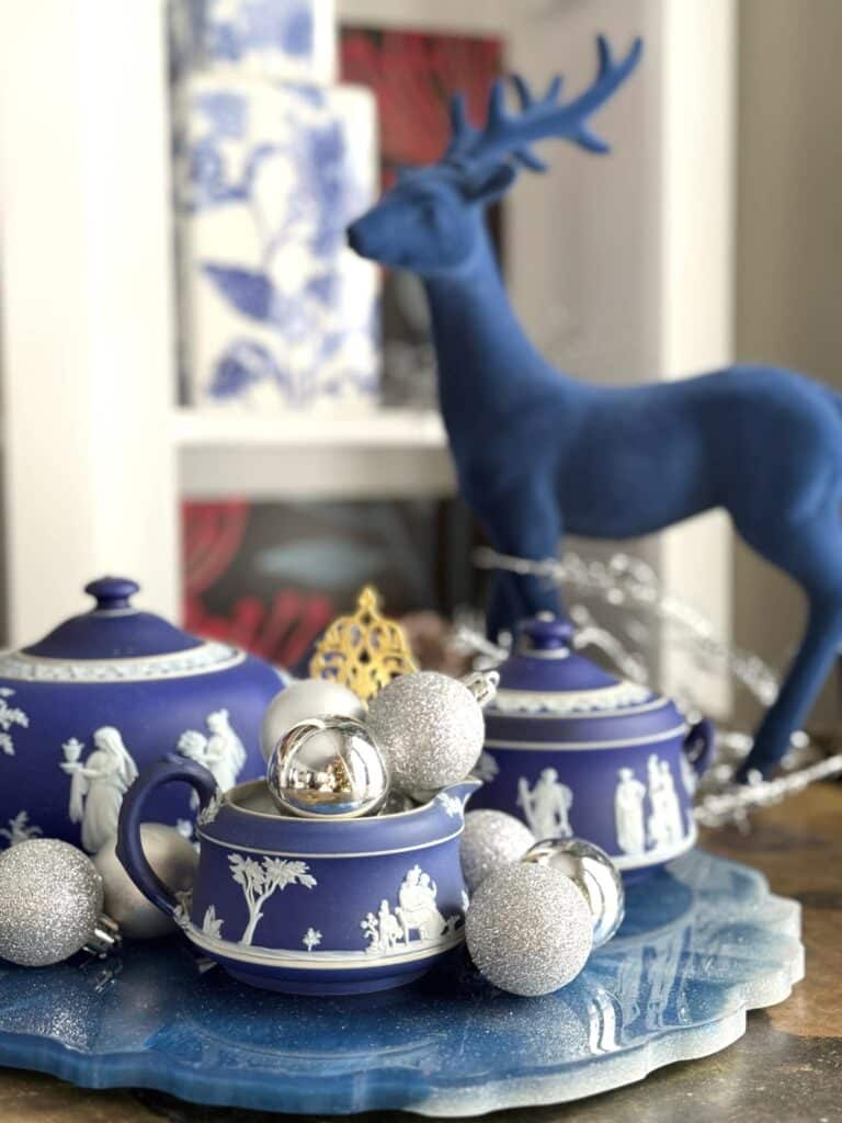 A blue Wedgewood tea set decorated with silver Christas ornaments.