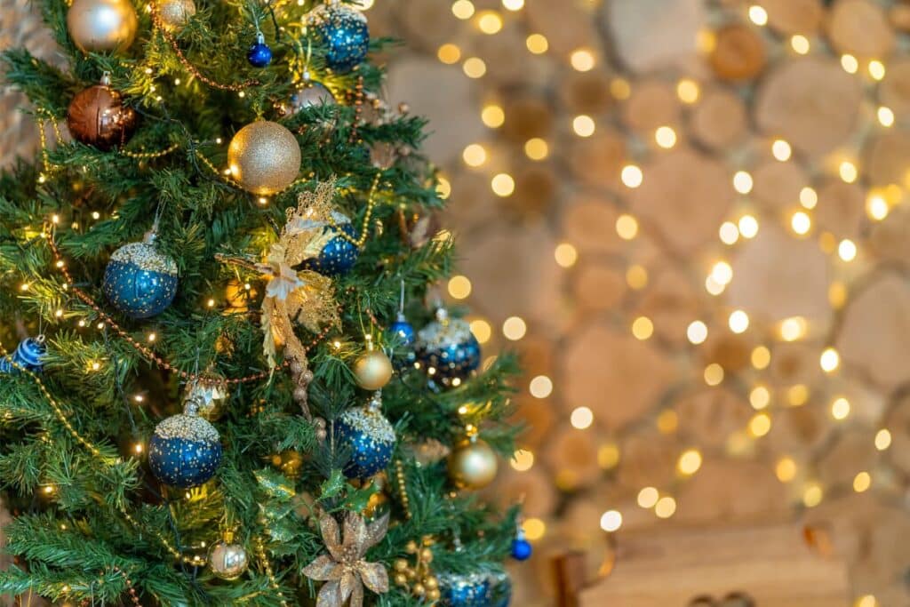 A green Christmas tree decorated with blue and gold ornaments.