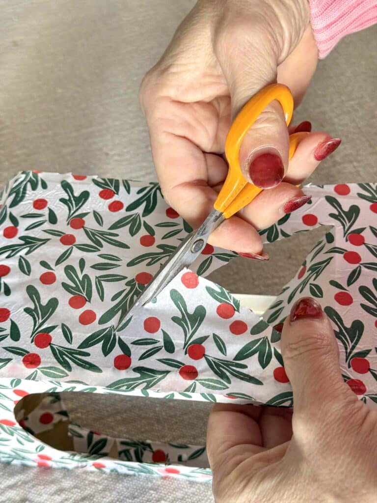 Trimming excess tissue paper fro a DIY Christmas lantern.