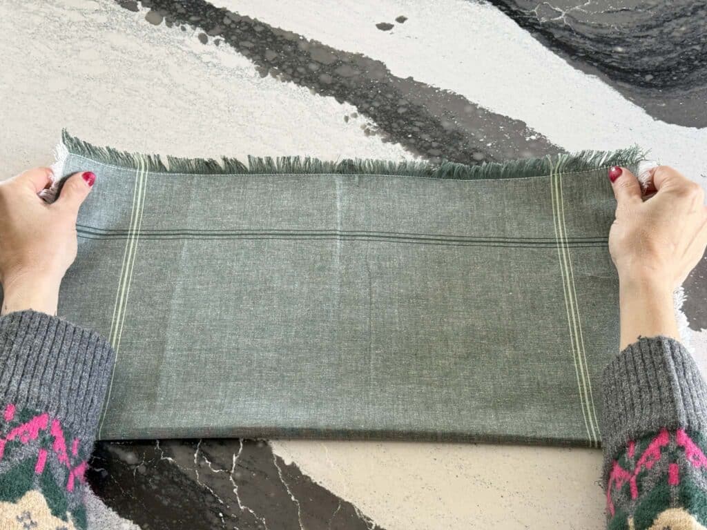 Folding a cloth napkin in half.